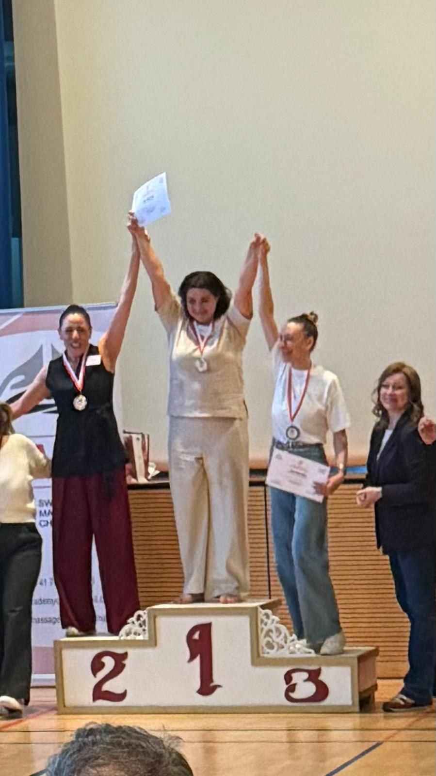 Tatiana Obrc auf dem obersten Podest einer Massage-Meisterschaft mit Medaille und Urkunde
